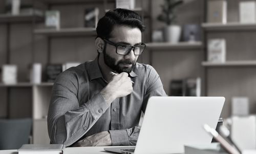 Man looking at laptop whilst working