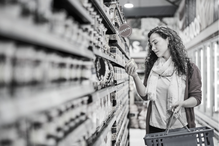 Women in supermarket picking out an item