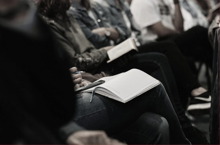 Someone taking notes at a meeting